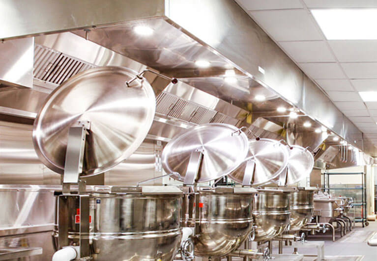Commercial kitchen with steam kettles and overhead ventilation